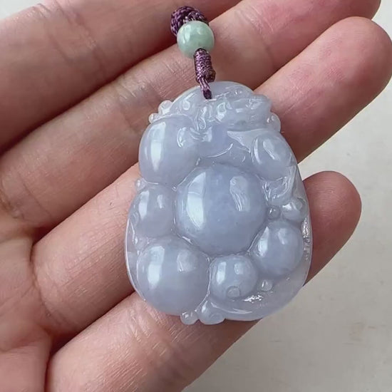 Video of a finely carved purple semi-translucent jade Pi Xiu with a luminous glow and abstract dragon-lion form