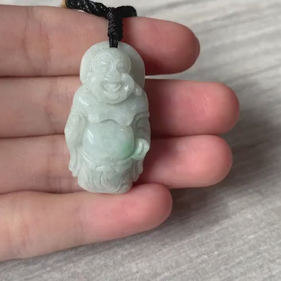 Video of a hand-carved natural jade Laughing Buddha pendant in green stone with a serene, traditional style