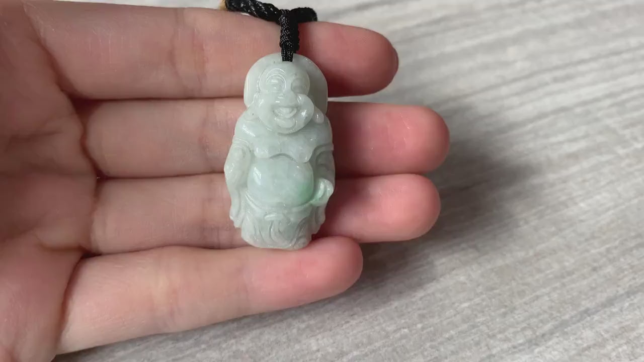 Video of a hand-carved natural jade Laughing Buddha pendant in green stone with a serene, traditional style