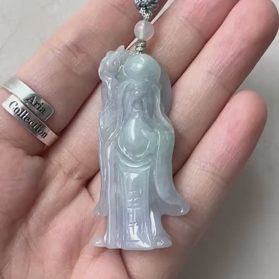 Video of hand-carved jade pendant in green with Shòuxīng figure, long beard, serene face, and traditional robes
