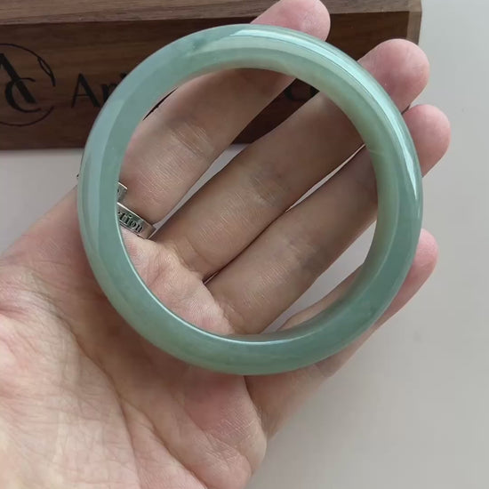 Video of a polished Burmese Type A jadeite bangle in soft light green-blue with a smooth, substantial rounded profile