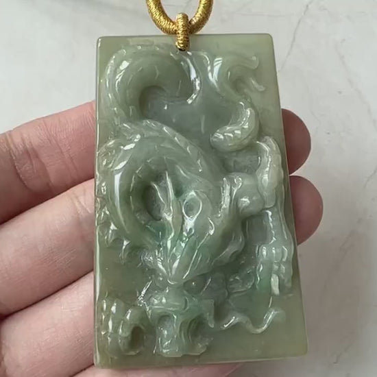 Video of green jadeite jade dragon pendant with intricate hand-carved scales, curling tail, and expressive face