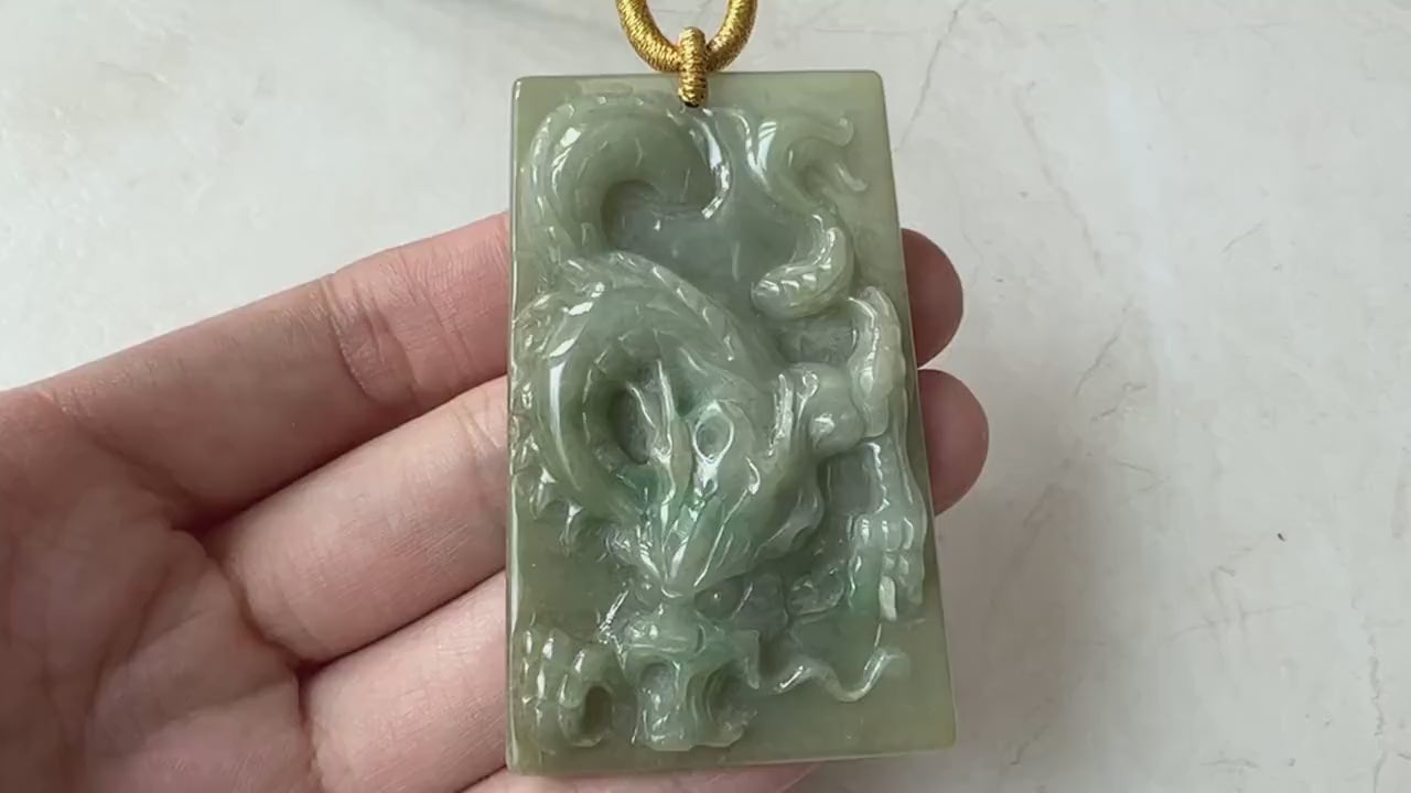 Video of green jadeite jade dragon pendant with intricate hand-carved scales, curling tail, and expressive face