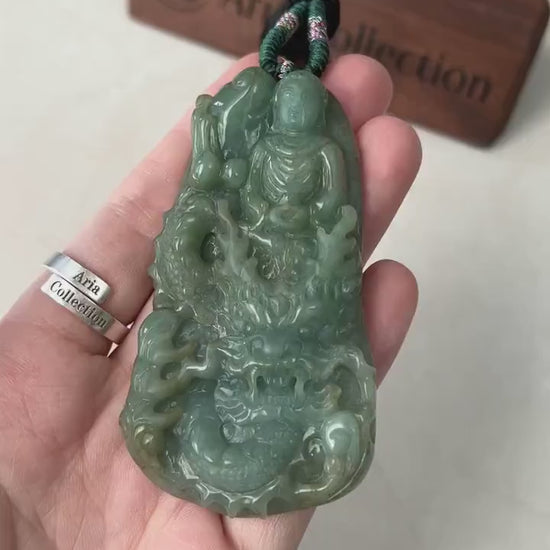 Video of vibrant green jade pendant with carved Buddha and dragon, glowing with intricate spiritual detail
