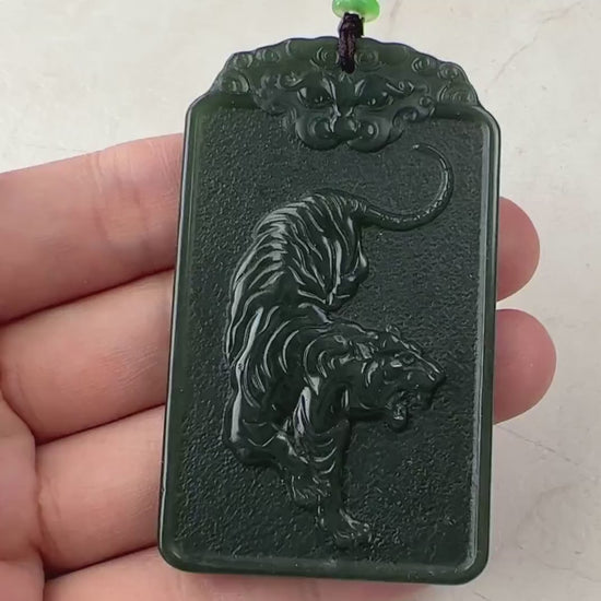 Video of a hand-carved green jade Akasagarbha Buddha pendant with sword detail and tiger reverse, elegant and symbolic