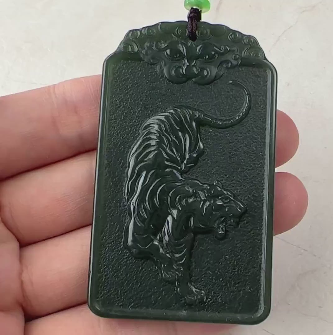 Video of a hand-carved green jade Akasagarbha Buddha pendant with sword detail and tiger reverse, elegant and symbolic