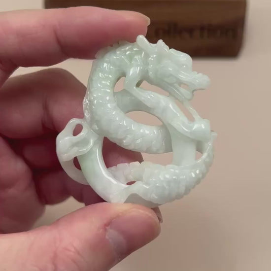 Video of a large green jadeite jade pendant with a hand-carved spiral dragon design and intricate details