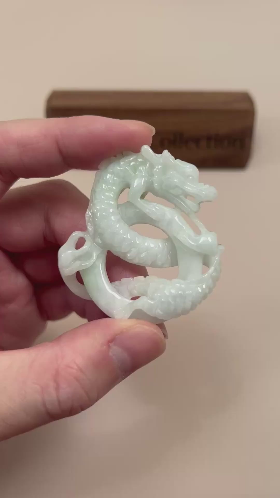 Video of a large green jadeite jade pendant with a hand-carved spiral dragon design and intricate details