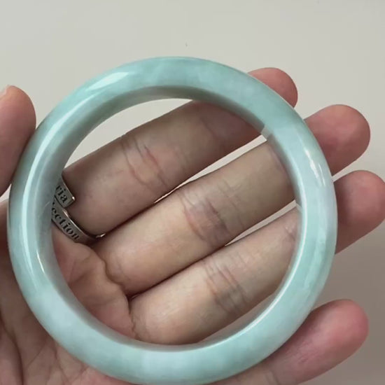 Video of pale green-blue natural jadeite jade bangle with glossy finish, cloudy translucency, and subtle natural veins