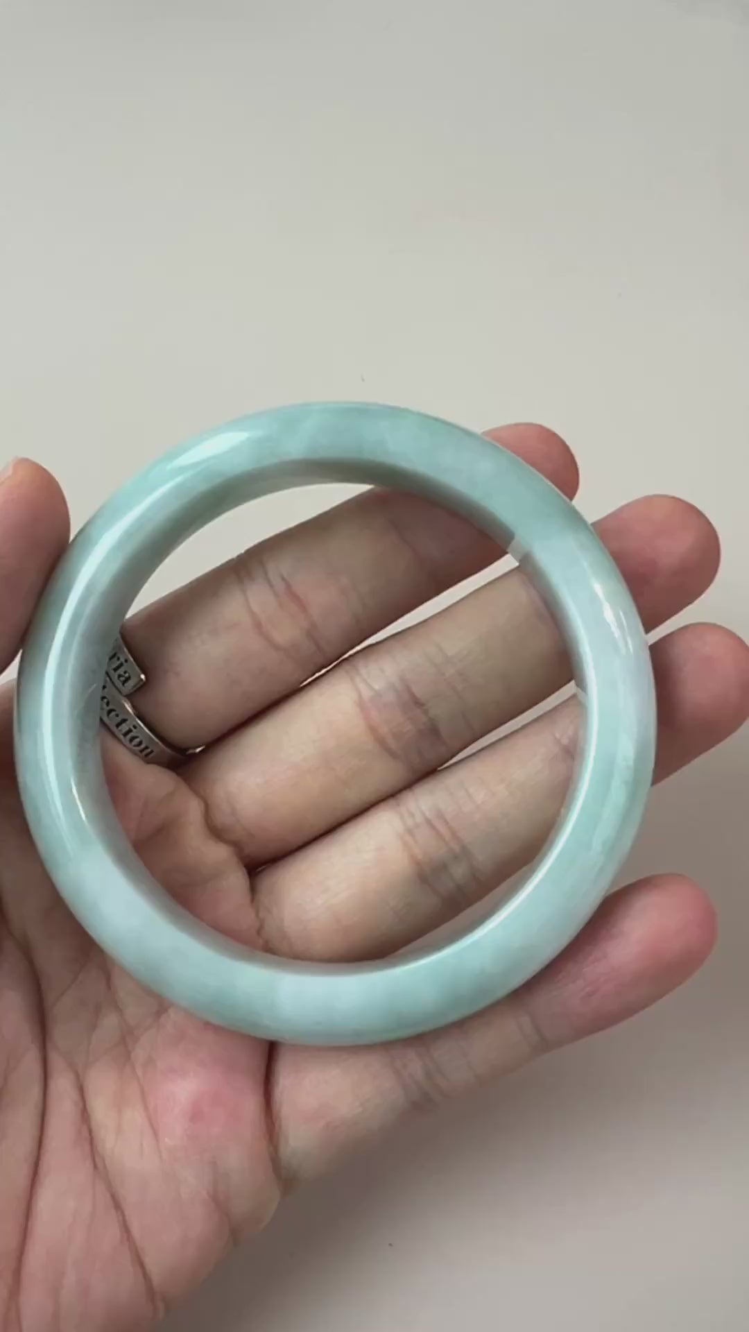 Video of pale green-blue natural jadeite jade bangle with glossy finish, cloudy translucency, and subtle natural veins
