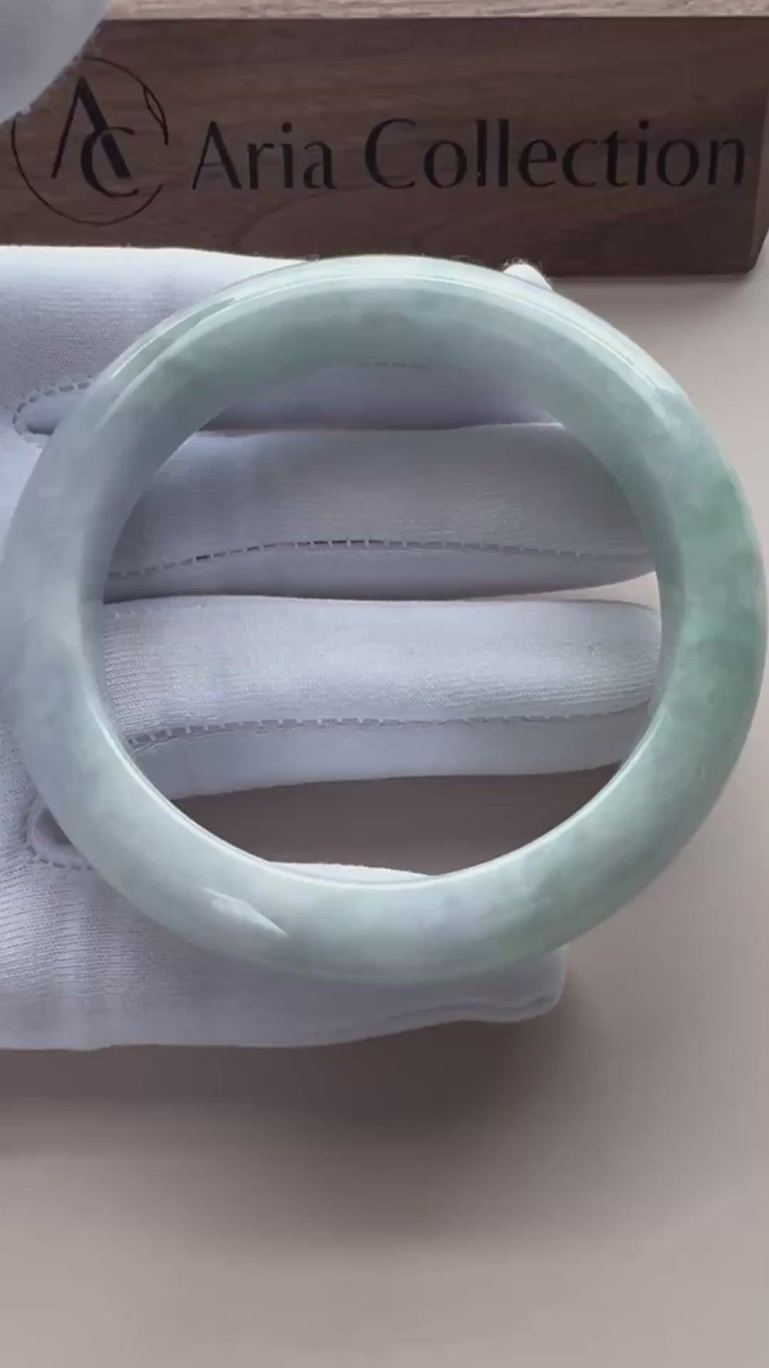 Video of a classic Burmese Type A jadeite bangle in icy light green with gray marbling and a high-polish rounded finish