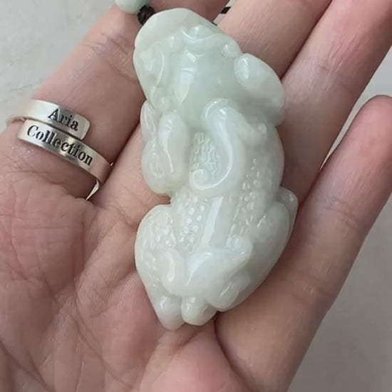 Video of a hand-carved green jade Pi Xiu pendant with traditional mythical dragon-lion detailing and elegant style