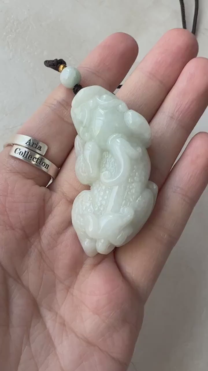 Video of a hand-carved green jade Pi Xiu pendant with traditional mythical dragon-lion detailing and elegant style