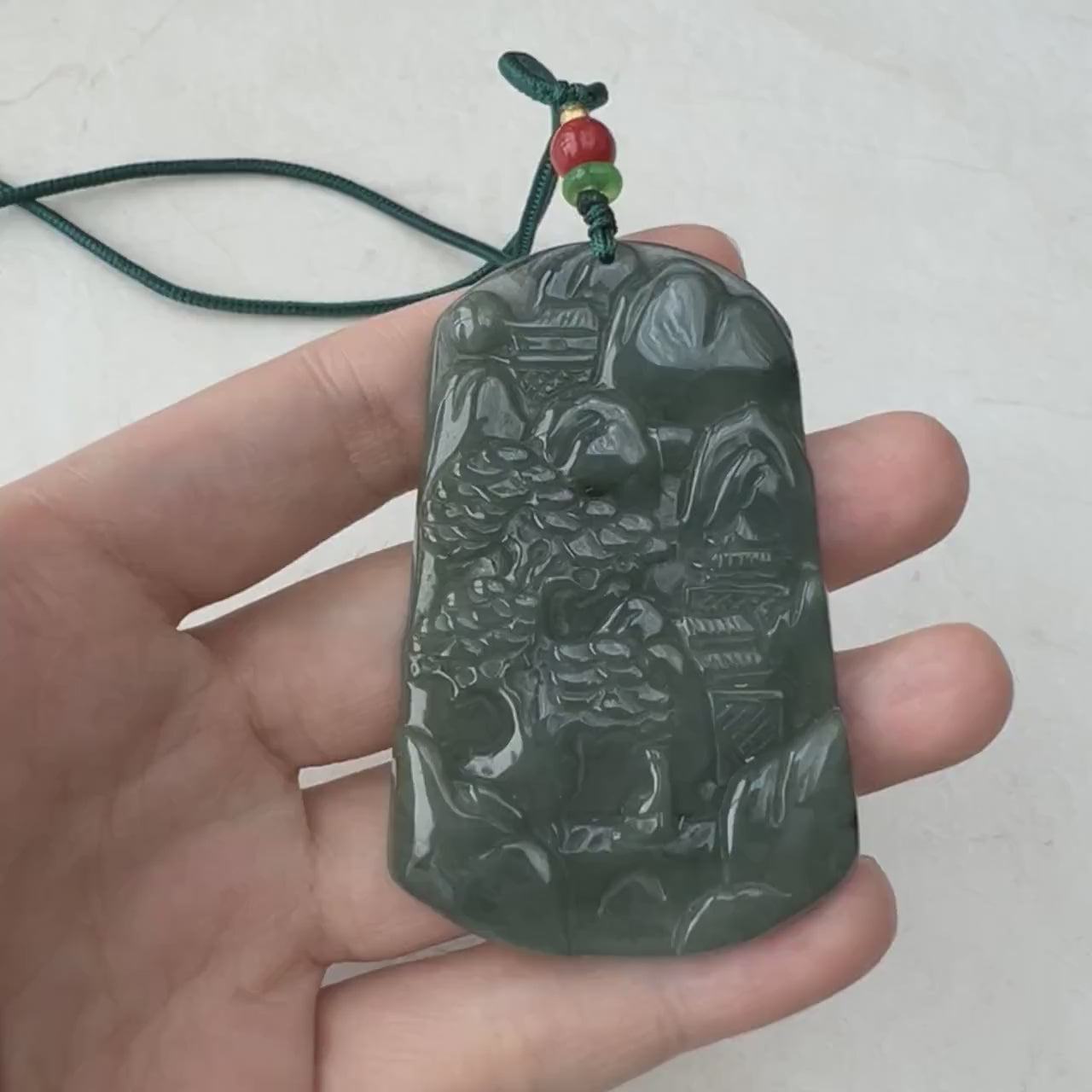 Video of a one-of-a-kind hand-carved dark green jadeite jade pendant with rich natural tones and fine detail