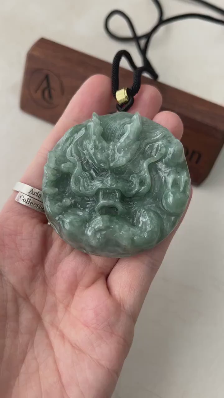 Video of a round green jadeite pendant with a hand-carved Chinese dragon, intricate and elegant.