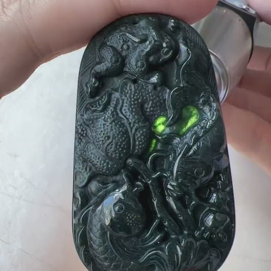 Video of a hand-carved natural jade pendant with two fish, detailed floral reverse, elegant green artisan style