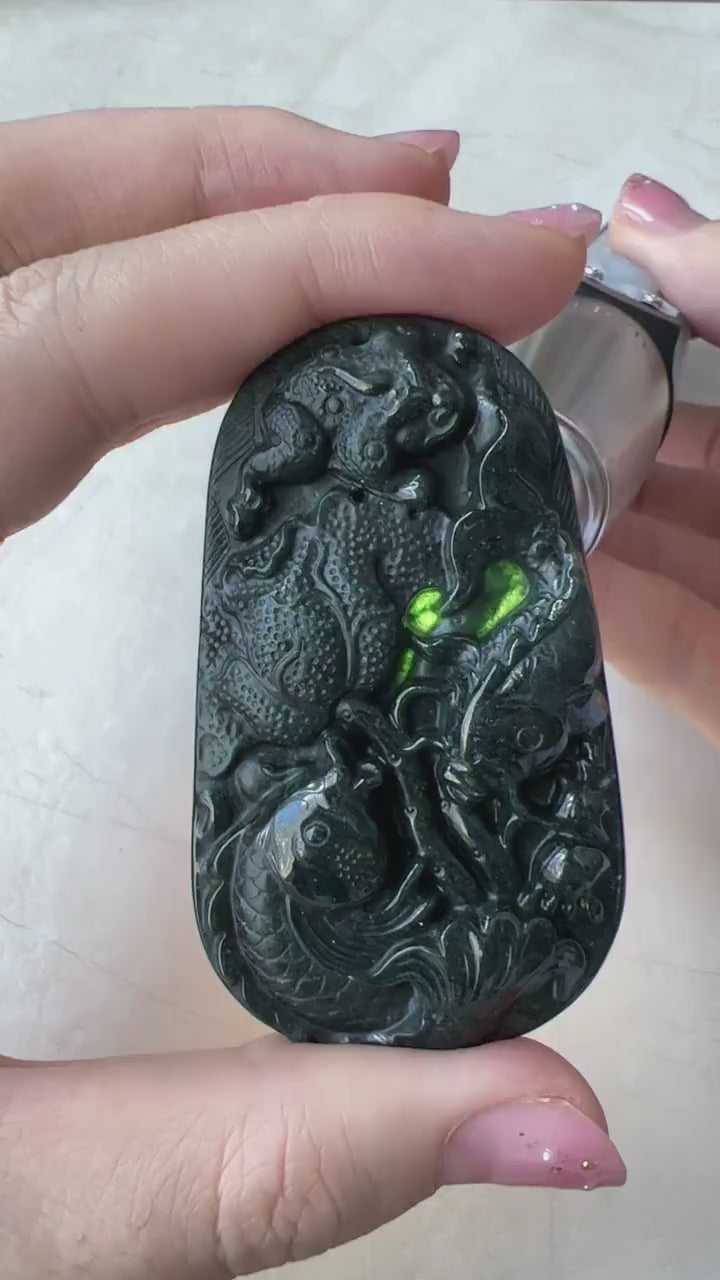 Video of a hand-carved natural jade pendant with two fish, detailed floral reverse, elegant green artisan style