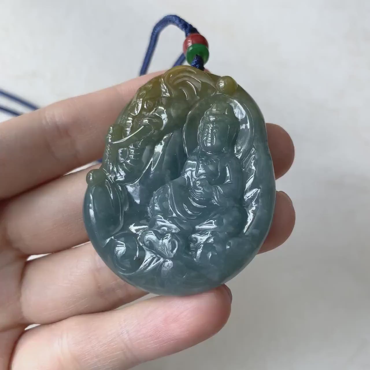 Video of a hand-carved green jade Guan Yin pendant with elephant, serene Buddhist style and elegant detail