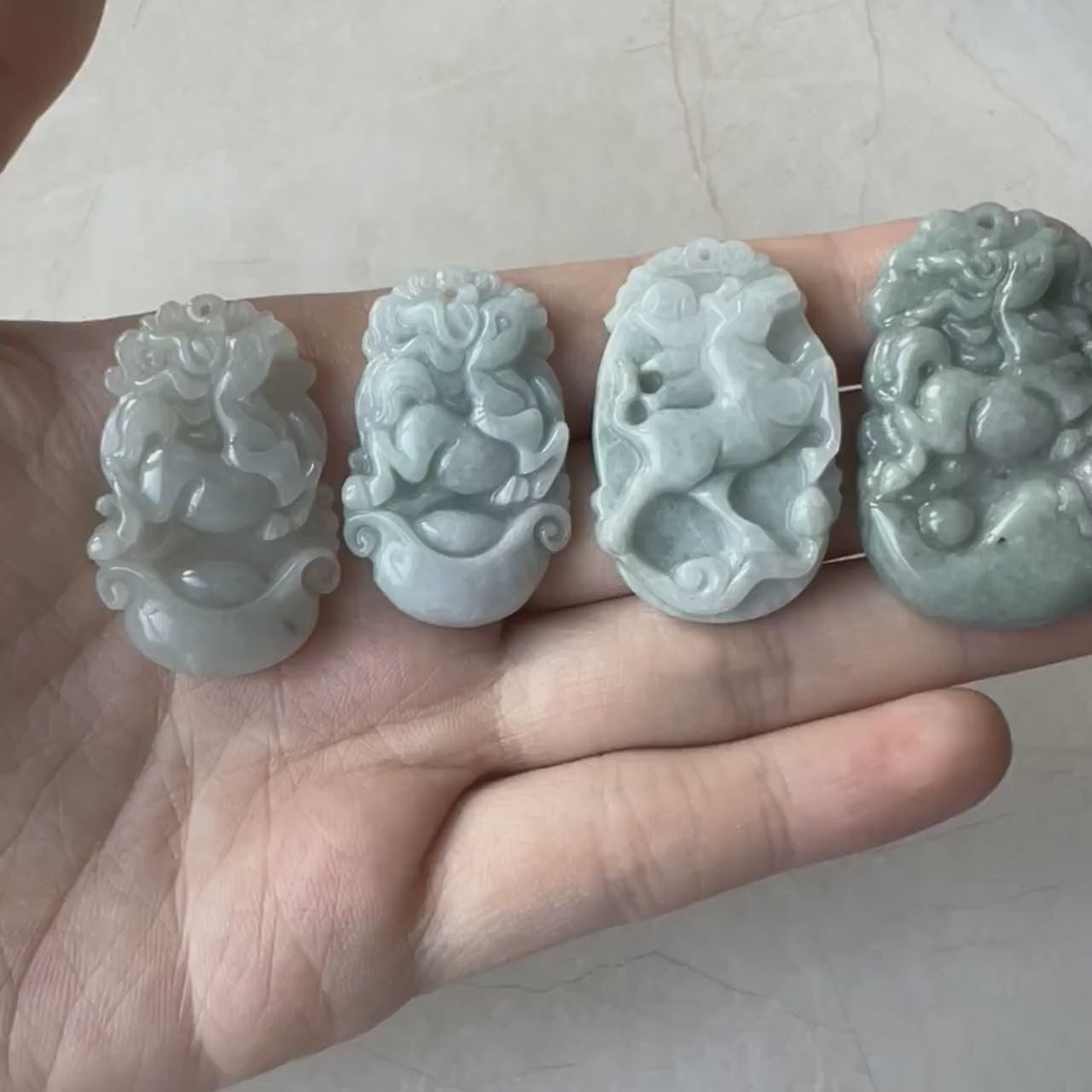Video of four Chinese Zodiac Horse jade pendants in varied natural colors and textures, finely carved and elegant
