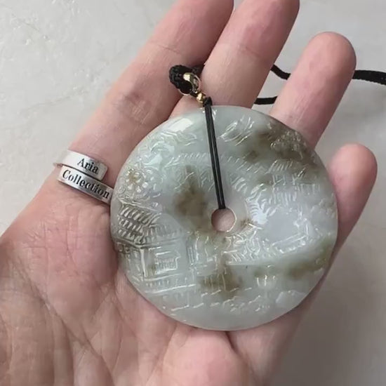 Video of a one-of-a-kind green jade pendant with hand-carved mountain and forest landscape design