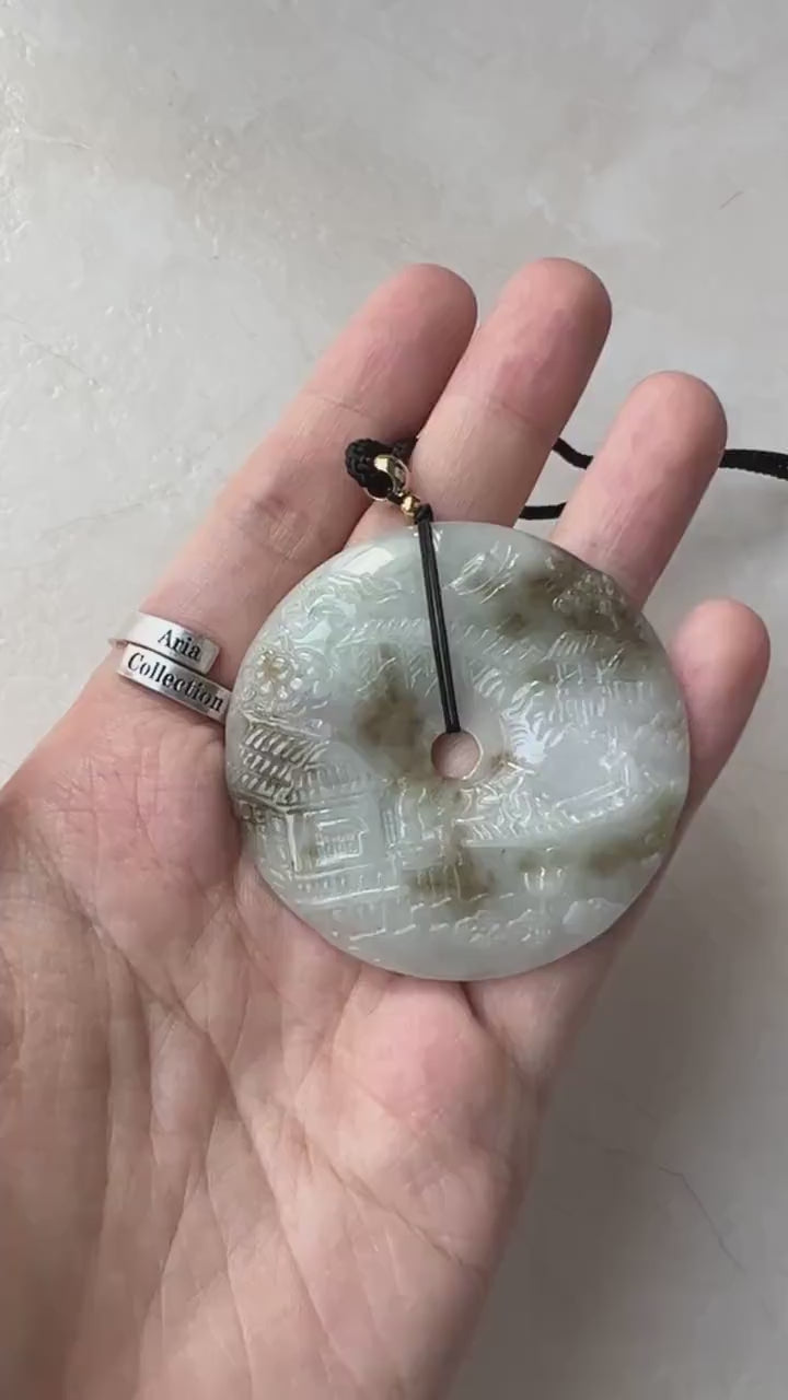 Video of a one-of-a-kind green jade pendant with hand-carved mountain and forest landscape design