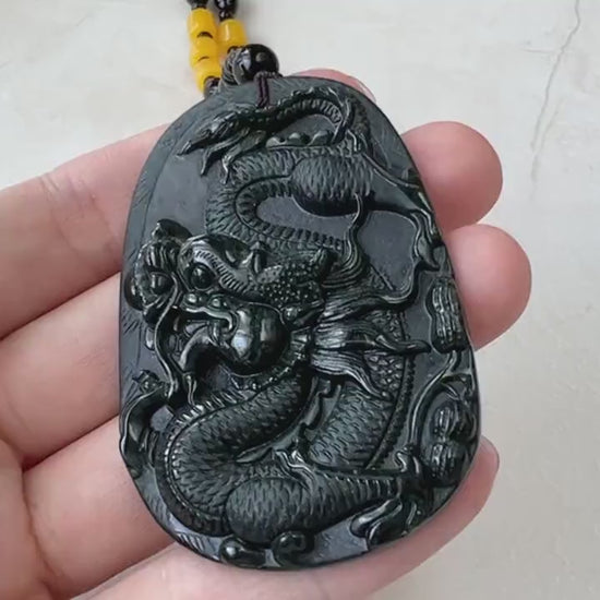 Video of a hand-carved black omphacite jade dragon pendant with glossy finish and decorative bead necklace