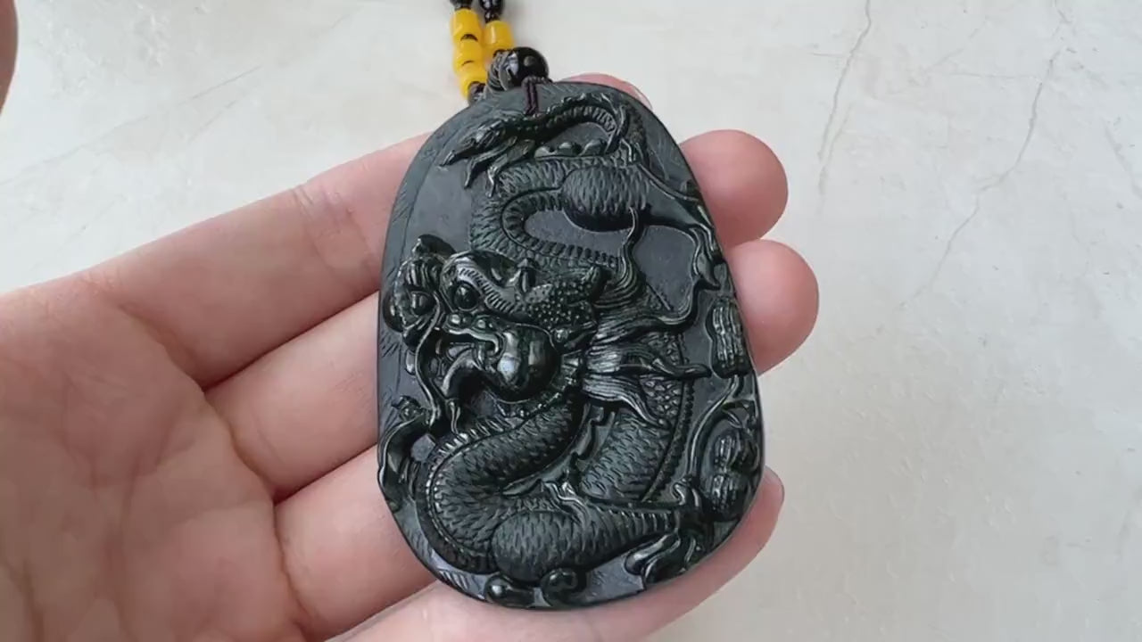 Video of a hand-carved black omphacite jade dragon pendant with glossy finish and decorative bead necklace