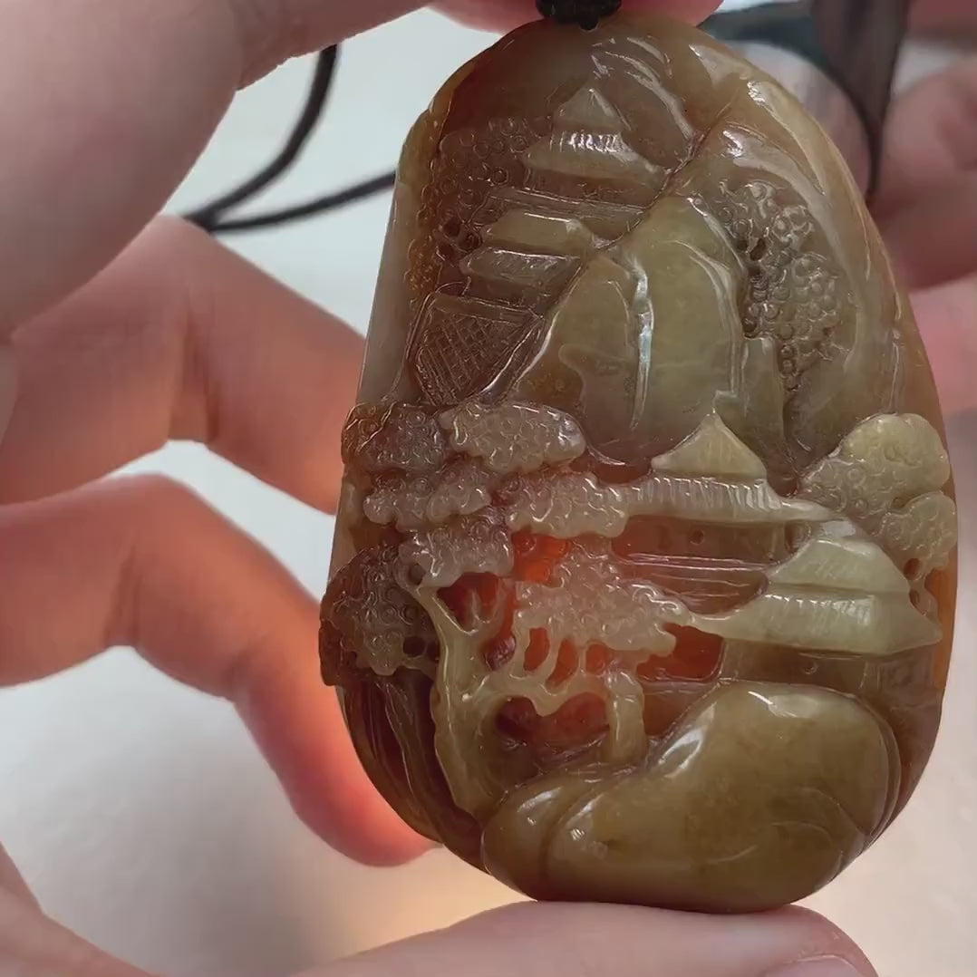 Video of a hand-carved jade pendant with red and yellow tones, autumn mountain landscape, and intricate double-sided detail