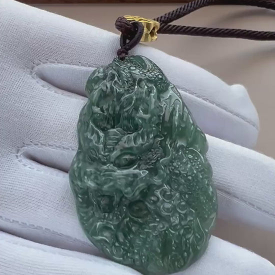 Video of a deep green natural jade pendant with pale mottling, carved Guan Gong and dragon, glossy polished finish