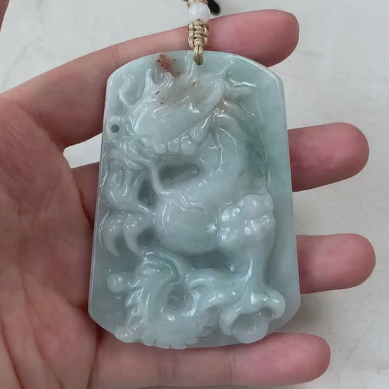 Video of a hand-carved green jadeite dragon pendant with red accents and intricate traditional detailing