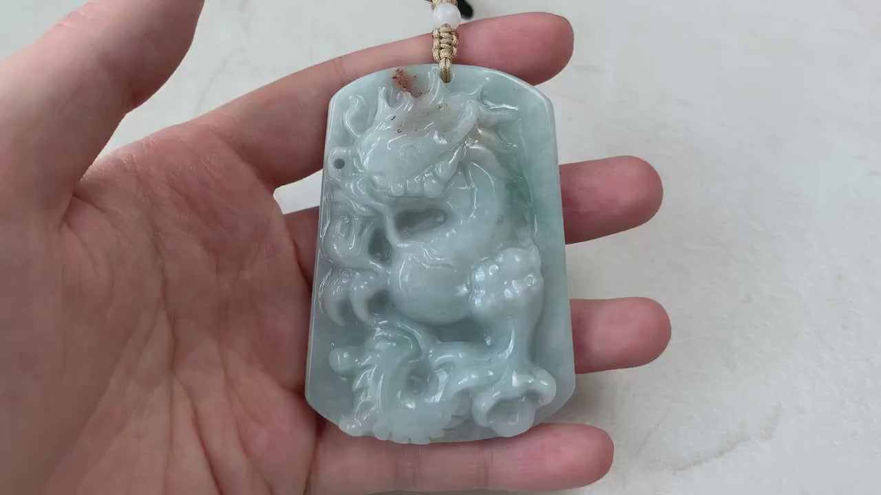 Video of a hand-carved green jadeite dragon pendant with red accents and intricate traditional detailing