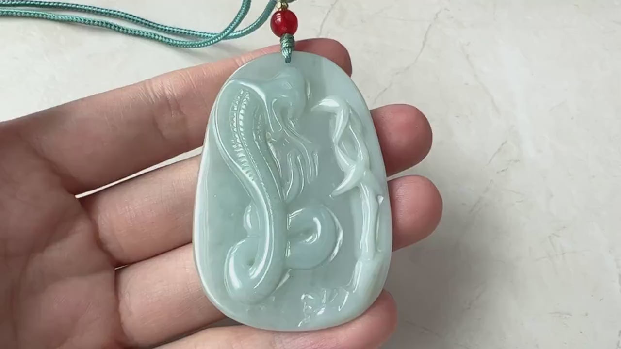 Video of a hand-carved green jade snake pendant with intricate traditional artisan detailing and forked tongue