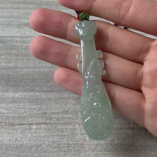 Video of a hand-carved semi-translucent green jadeite pipa pendant with elegant traditional Chinese curves