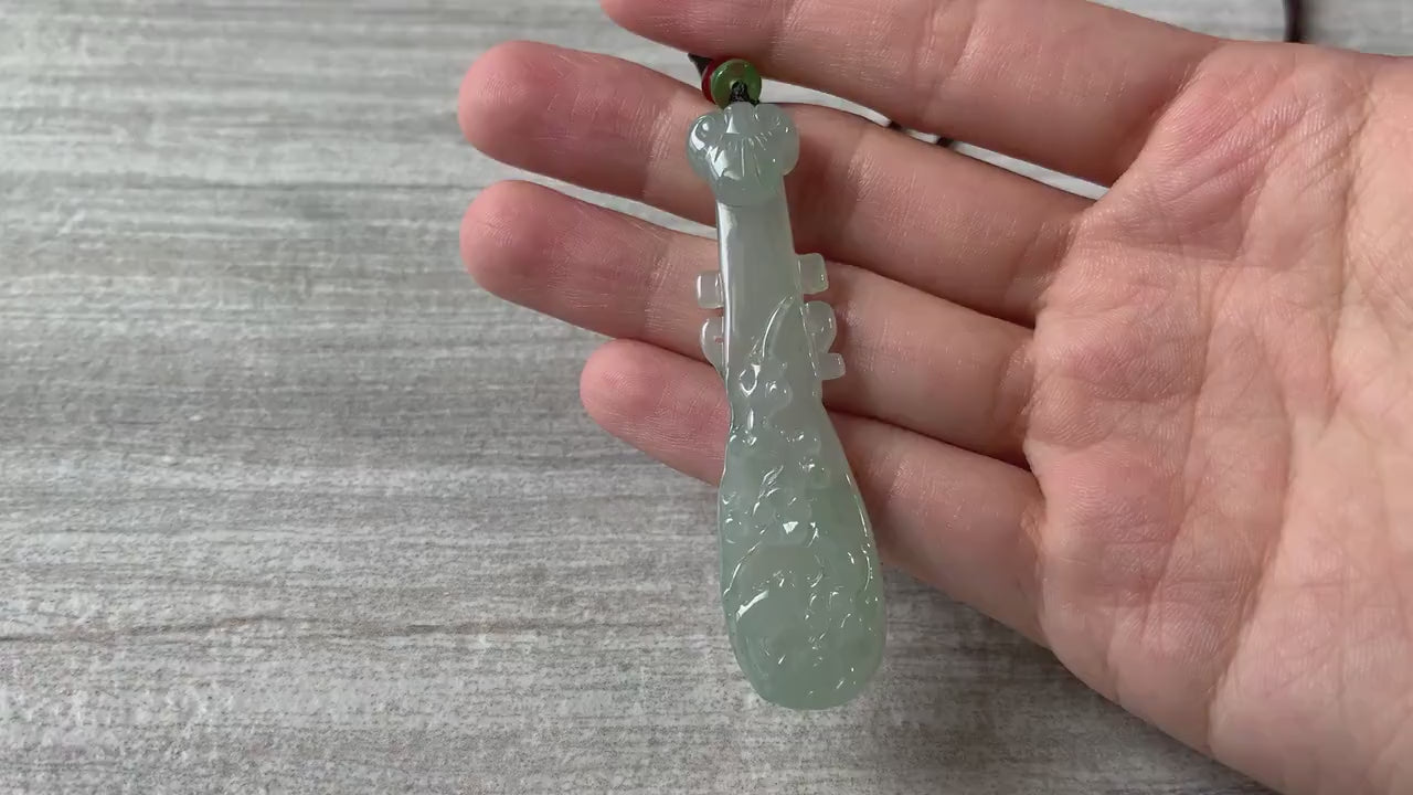 Video of a hand-carved semi-translucent green jadeite pipa pendant with elegant traditional Chinese curves