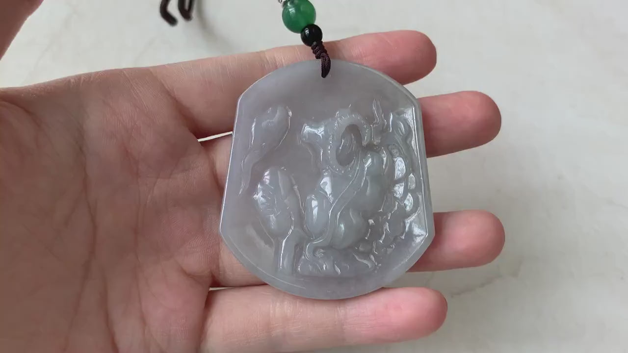 Video of a hand-carved jadeite jade Ox pendant in soft light gray-blue with a smooth, semi-translucent glow.