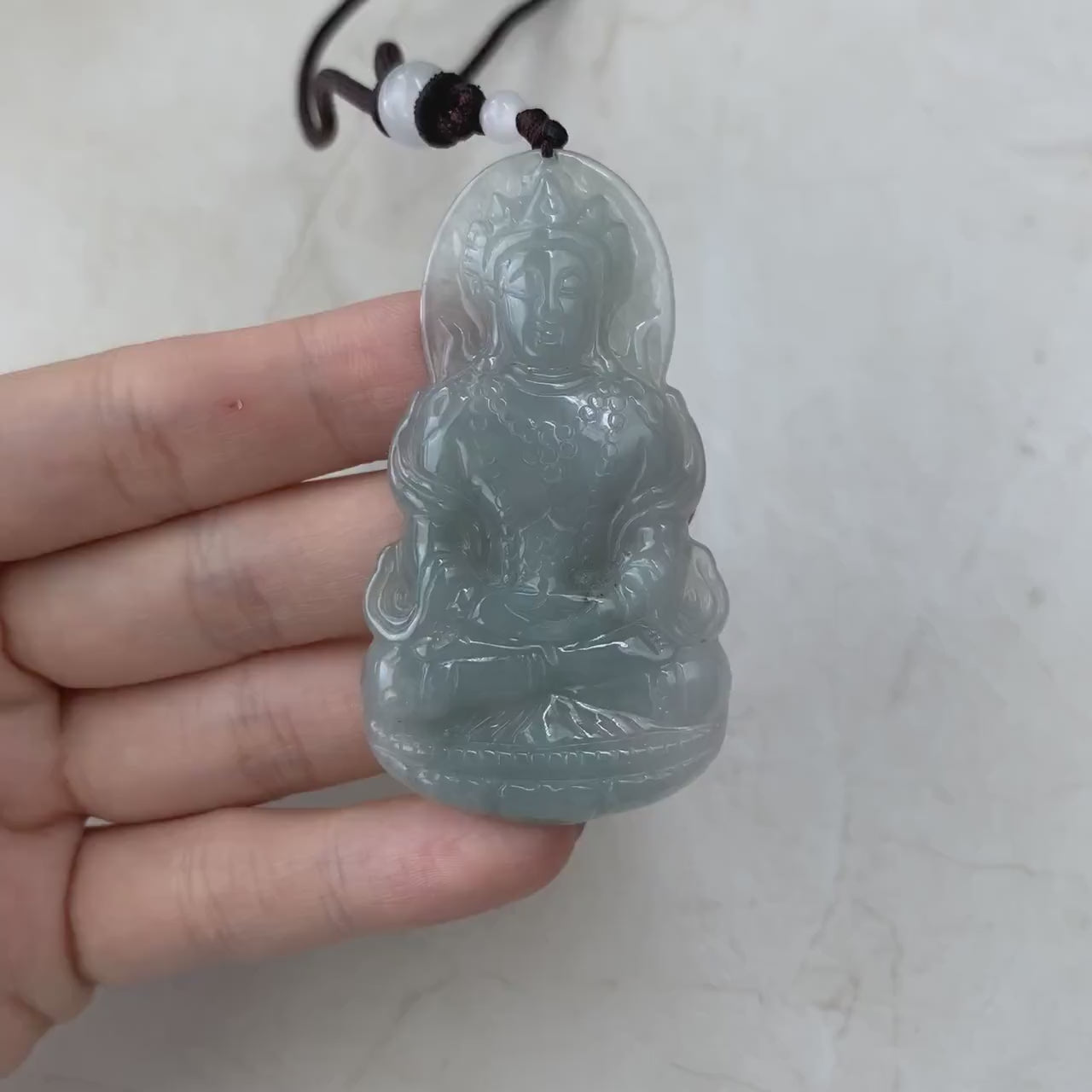 Video of a one-of-a-kind natural jade pendant with hand-carved meditating Guan Yin on a lotus, intricate green detail