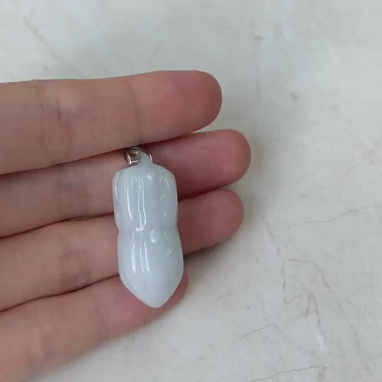 Video of a hand-carved white jade peanut pendant with subtle green-gray tones on an 18-inch faux leather necklace