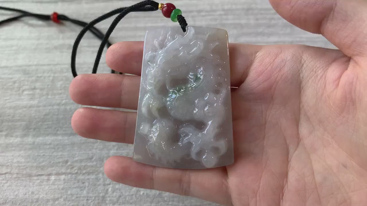 Video of a hand-carved jadeite jade dragon pendant with intricate scales, claws, and tail in rich green tones