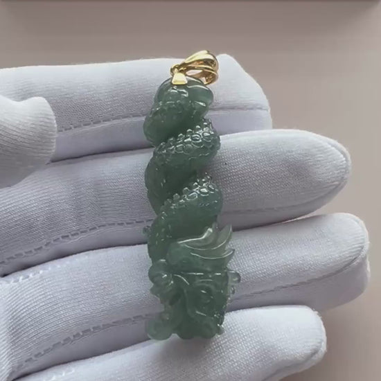 Video of an elongated deep green natural jade pendant with carved scales, polished finish, and gold-tone bail