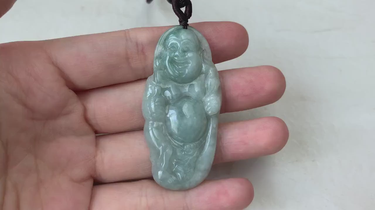 Video of a hand-carved green jade Laughing Buddha pendant with smooth, detailed traditional carving and joyful expression