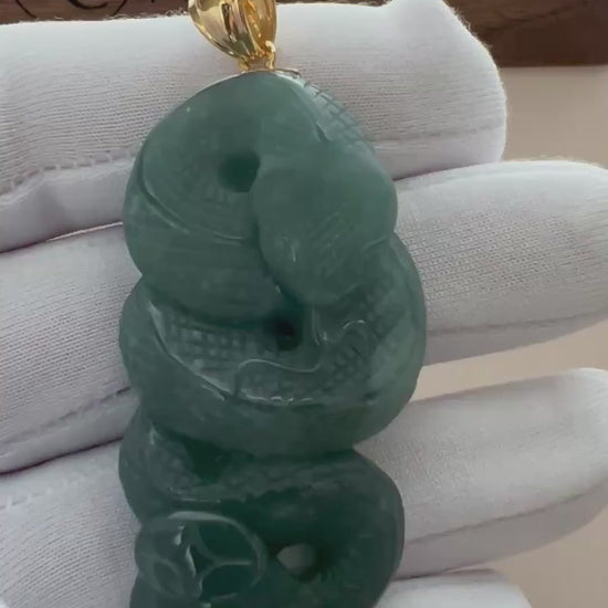 Video of a teal-green natural jade pendant with carved coiled serpent, polished finish, and gold-tone bail