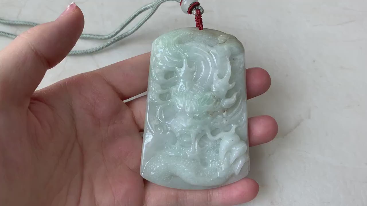 Video of a large light green jadeite pendant with a detailed hand-carved Chinese dragon design