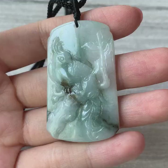 Video of a hand-carved green jade pendant with a bird and delicate plum blossom motif, showcasing fine craftsmanship