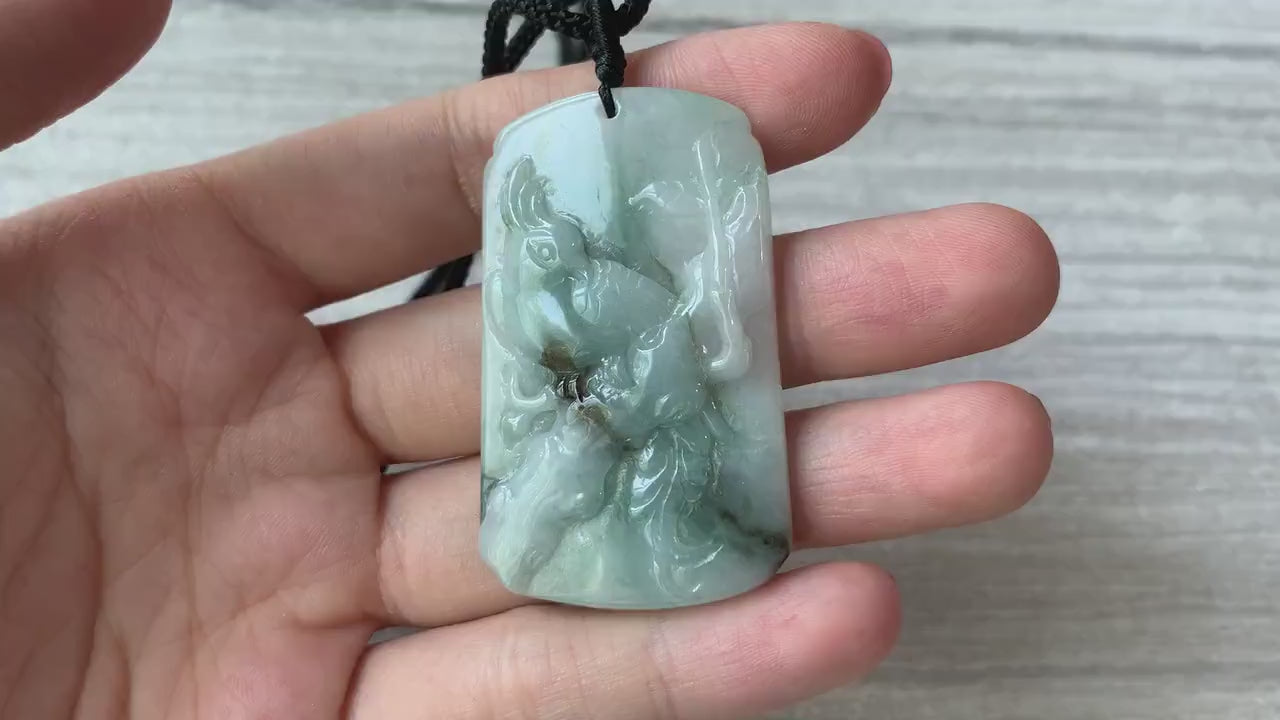 Video of a hand-carved green jade pendant with a bird and delicate plum blossom motif, showcasing fine craftsmanship