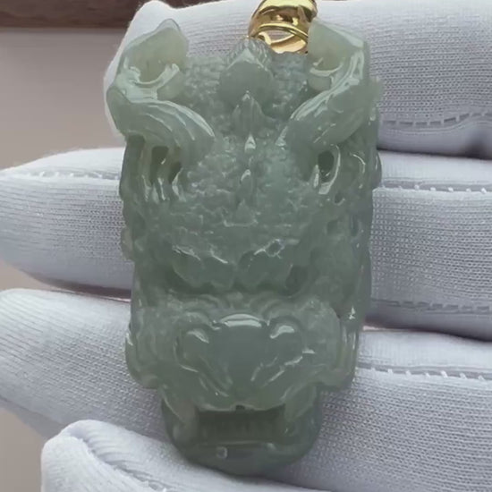 Video of pale green natural jade dragon head pendant with translucent carving, openwork details, and gold-tone bail
