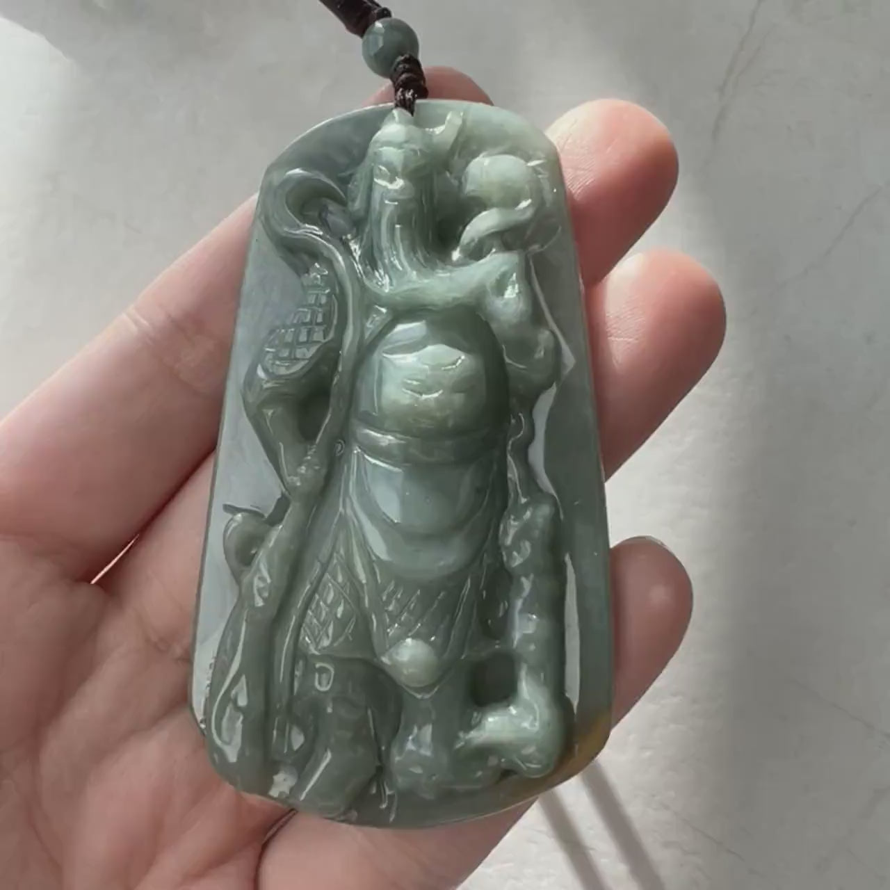 Video of a hand-carved natural jadeite jade Guan Gong pendant with crisp detailed carving and rich green stone.