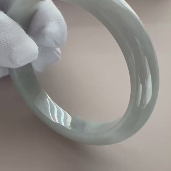 Video of a light gray Burmese Type A jadeite bangle with translucent polish, classic profile, and subtle speckles