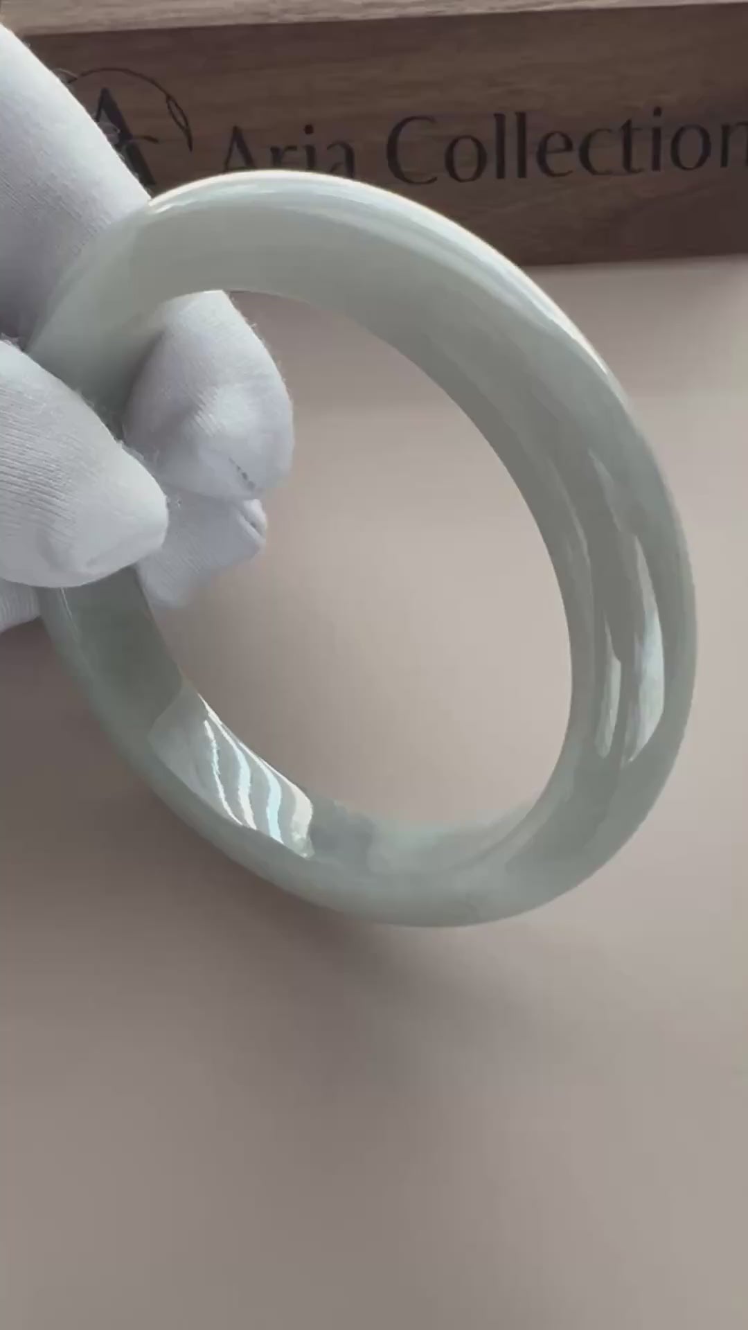 Video of a light gray Burmese Type A jadeite bangle with translucent polish, classic profile, and subtle speckles