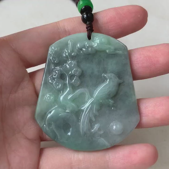 Video of a hand-carved pendant with a bird and floral details, celebrating nature in an elegant organic style