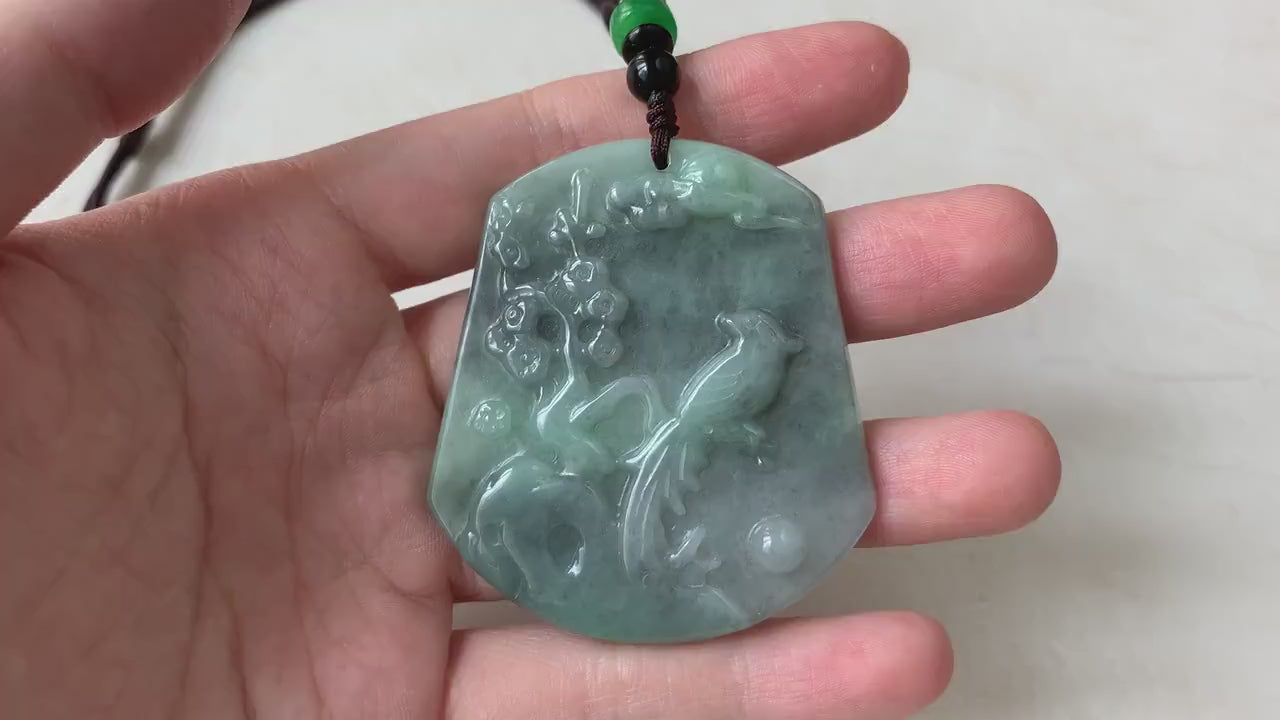 Video of a hand-carved pendant with a bird and floral details, celebrating nature in an elegant organic style